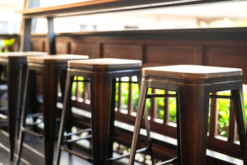 Group of tall wooden and iron retro style seats at the coffee counter bar. Furniture object photo,...