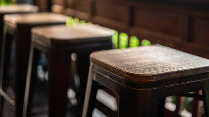 Group of tall wooden and iron retro style seats at the coffee counter bar. Furniture object photo,...