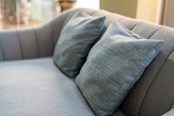 Cozy style grey pillows on sofa seat. Interior furniture decoration object, close-up. - obrazy, fototapety, plakaty