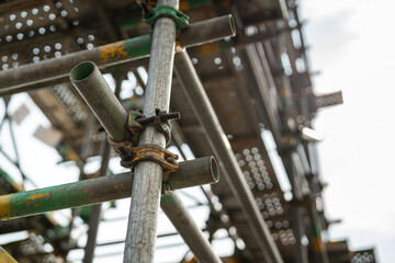 Close-up at metal pipe connection joint of the working platform scaffold at the construction work...