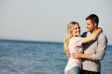 Couple, portrait and hug by beach for love, peace and travel to nature for holiday. People, embrace and calm on weekend or vacation, blue sky and date for relationship or marriage and ocean waves