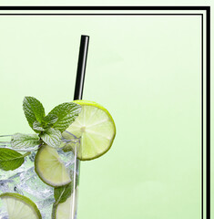 Cut out view of Mojito cocktail with mint, lime and black drinking straw on green framed background. Cocktail bar advertising image.