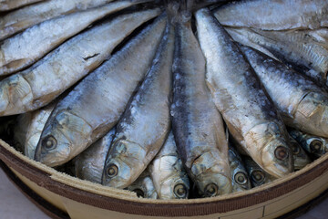 Smoked herrings arranged in their box, displayed at a popular market.