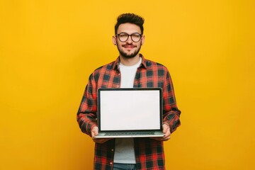 Man in causal clothing holding laptop yellow background - obrazy, fototapety, plakaty