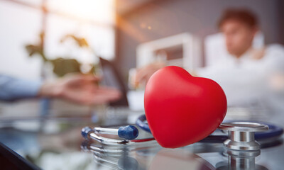 Stethoscope and red heart on wooden table. Cardiology concept
