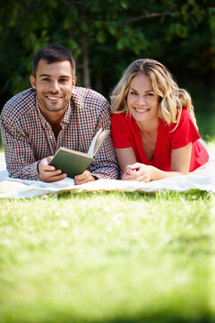 Couple, grass and park with book in portrait for relax, reading or together with notebook. Man, woman and nature for stress relef or break and bonding, chill or picnic and relationship with holiday