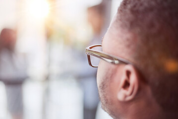 portrait of a black guy stands with his back and looks at his colleagues in the office