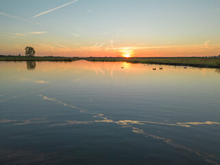 Sunset above the lake and nature area.
