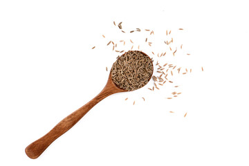 Top view of zira seeds or cumin seeds on a spoon over a white background.