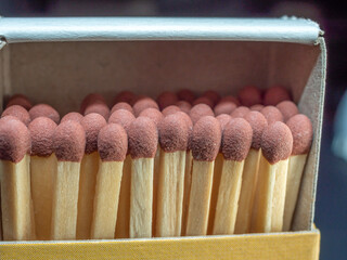 Heads of wooden matches in an open matchbox. Close-up
