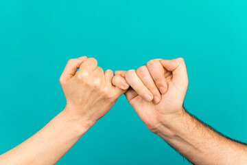 Photo of two people arms palms having fingers crossed reconciliating isolated teal color background