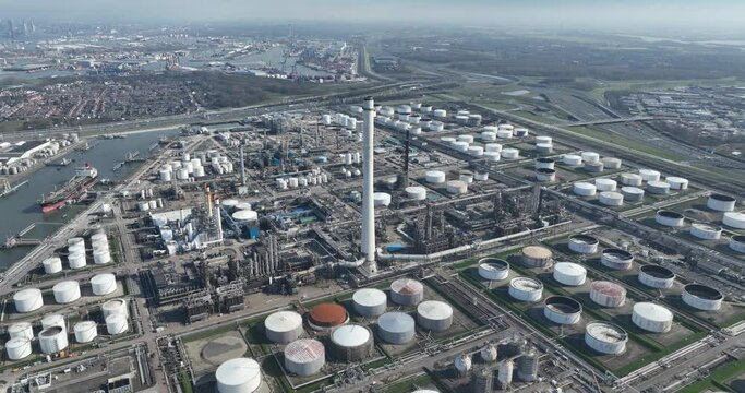 Large petrochemical refinery in Pernis, the Netherlands. Large industrial installation facility. Storage containers, silos and pipeline in port harbor environment.