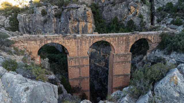 Majest&auml;tische Drohnenaufnahme der antiken Steinbr&uuml;cke Pe&ntilde;a Cortada in den Bergen
