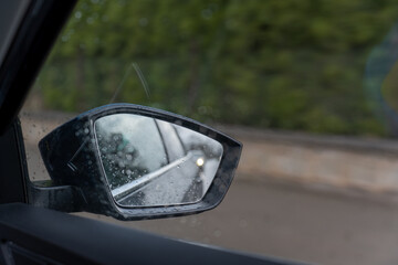 The car mirror and the raindrops.  - obrazy, fototapety, plakaty