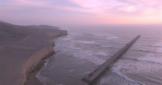 Shot of dock at sunset, with the seafront behind. Aerial shot of the Puerto Eten beach sea at sunset.