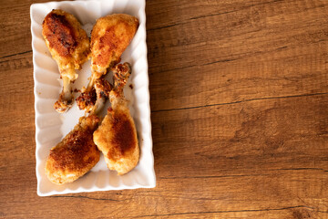 Fried chicken thighs on square plate on table