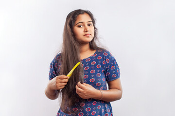 indian women combing frizzy long hair in white background