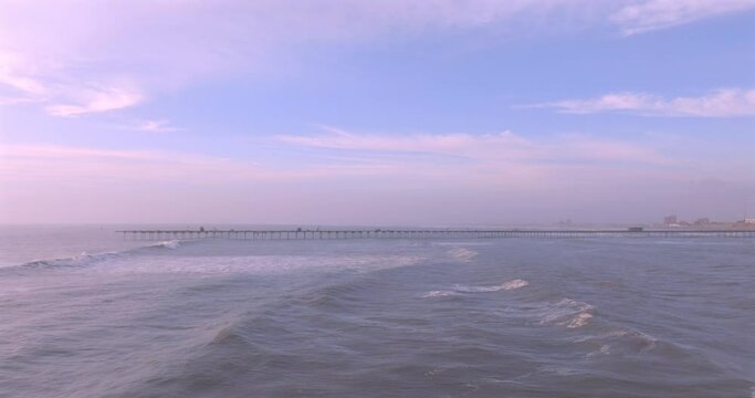 Shot of dock at sunset, with the seafront behind. Aerial shot of the Puerto Eten beach sea at sunset.
