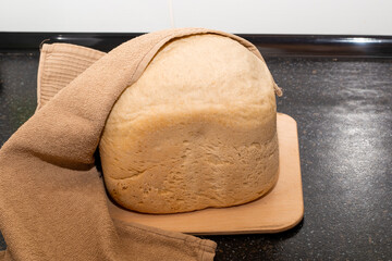 A loaf of freshly baked homemade bread from a bread machine. Cook at home - obrazy, fototapety, plakaty