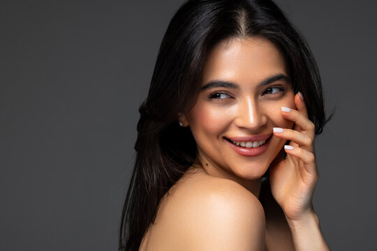 Gorgeous woman face portrait. Beauty Model Girl with bright eyebrows, perfect make-up, red lips, touching her face.