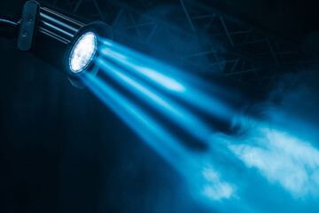Blue stage lights shine through atmospheric smoke, creating a dramatic concert or event setting