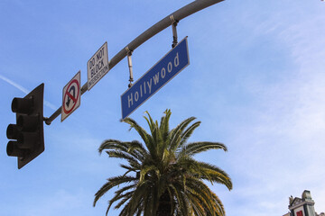 Hollywood Boulevard Street Sign And Traffic Light In Los Angeles California With Blue Sky Palm Tree