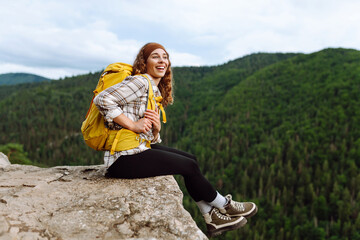 Naklejka na ściany i meble Woman tourist on top of mountain enjoying views of nature. Lifestyle, adventure, nature, active life.