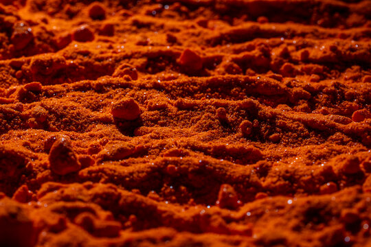 Small bright orange crystals of potassium dichromate, closeup, abstract colorful background