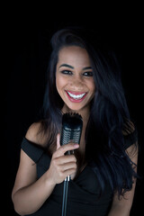Vibrant black singer with a captivating smile, holding a classic mic.