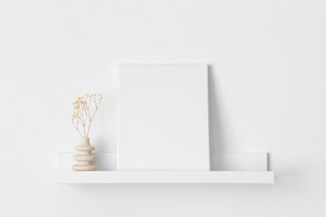 White canvas mockup with a gypsophila decoration on the wall shelf.