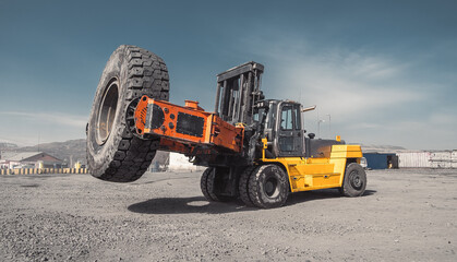 Tire manipulator, wheel loader for removal and installation of large-size wheels for mining wheeled vehicles, dump trucks and loaders. Yellow telehandler. Special equipment. Commercial Vehicles