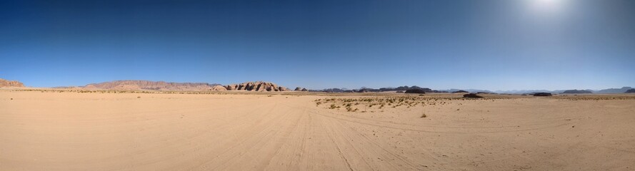 Panoramic view of Wadi Rum desert in Jordan with clouds moving over flat sand landscape with...