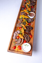Rustic wooden platter with assorted meats and vegetables