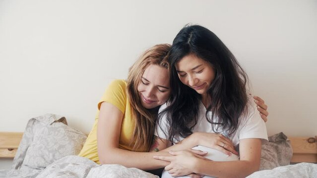 Happy pregnant asian korean woman with friend talking and laughing while celebrating baby shower at home bedroom. Family, woman love and romantic relationship. Beautiful asian girlfriend in lgbt home.