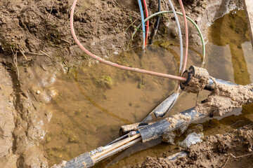 Disrupted during construction or repair work fiber optic cables for the internet lying in a trench.