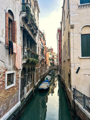 Fototapeta na wymiar View of canal with old house's facades and gondolas in famous destination Venice, Italy