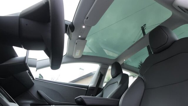 Panoramic glass sun roof in the new electric car. Clean glass and view from inside to the sky. Sunroof hatch with tinted glass. Automotive sunroof. Hatch in car roof