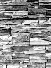 The vertical wall is made of natural brick, black and white, with limestone masonry. Texture for indoor or outdoor background, loft interior.