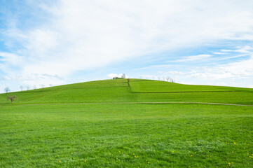 Landscape view of green grass on slope with blue sky