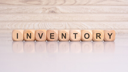 wooden blocks spelling 'INVENTORY' on a gray background