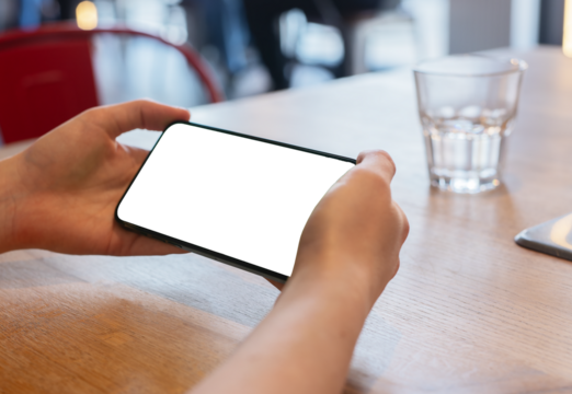 A closeup of a smartphone with an ad displayed, being used by a young woman