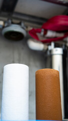 Naklejka premium Old and new water filters on filter system background. Plumbing water filter cartridge replace maintenance service.