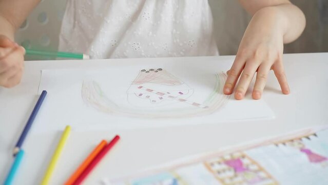 Close-up of a child's hands coloring a drawing with bright pencils. Young girl engaging in colorful artistic drawing and coloring activity using pencils. Enhancing creativity. Imagination