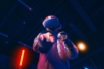 Young woman playing VR game in neon room.