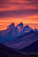 Silhouette of jagged mountain peaks with the sky painted in shades of orange, pink and purple colors,