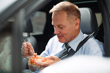 Businessman eating lunch in car