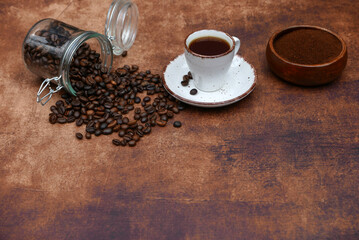 Kaffee mit gerösteten Kaffeebohnen auf rustikalem Hintergrund mit Platz für Text.