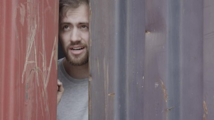 Frustrated man stuck between shipping containers