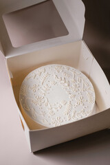 white cake in a white cardboard box. Delivery of sweets and gifts