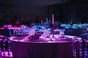 Beautifully organized event - round served table banquet ready for guests, round decorated table with empty plate, glasses, forks, napkin. Elegant dinner table 
